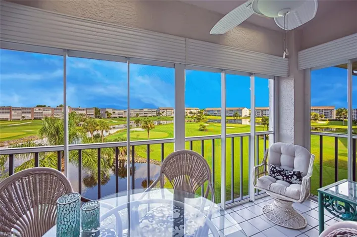 Sunroom with outdoor dining space, tile patterned flooring, a water view, ceiling fan, and view of golf course