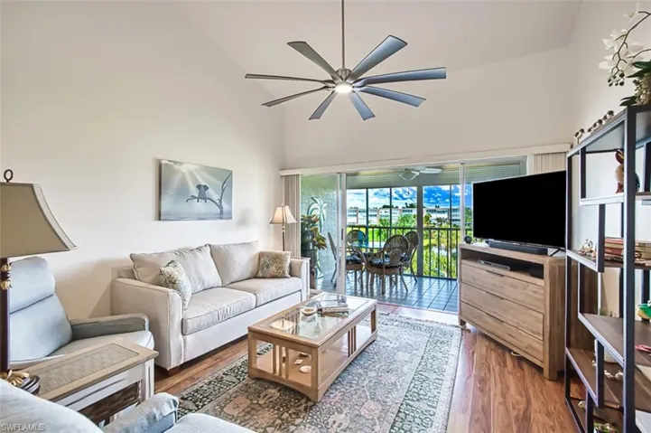 Living room featuring ceiling fan, wood finished floors, and high vaulted ceiling