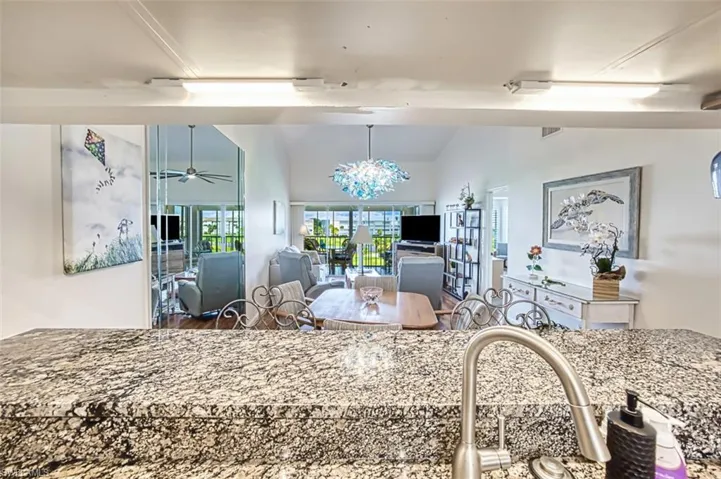 Dining room with vaulted ceiling, a ceiling fan, and a chandelier