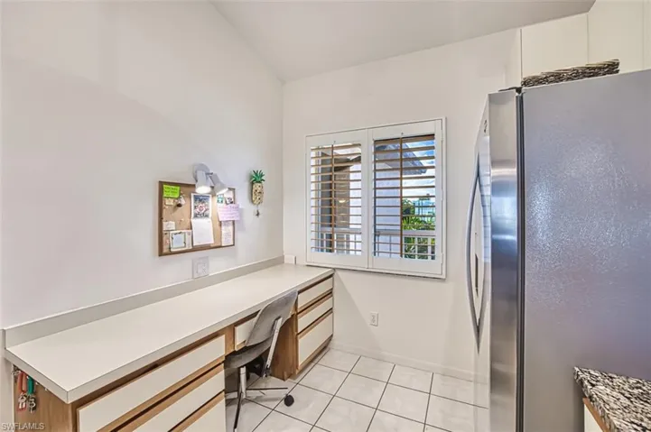 Office space featuring built in desk and light tile patterned floors