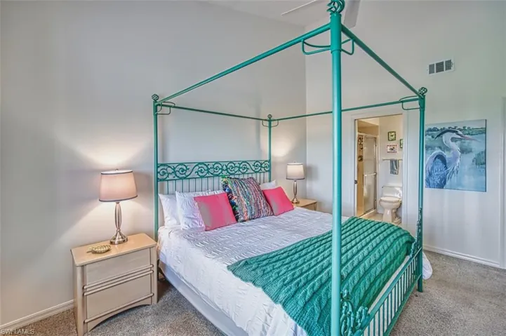 Carpeted bedroom featuring baseboards and ensuite bath