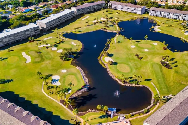 Drone / aerial view of a golf course and a nearby body of water