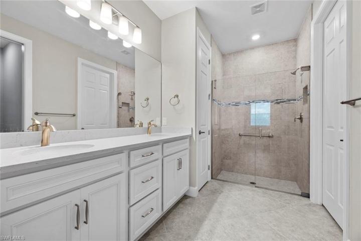Master bath with dual sinks, quartz counter tops, and large step-in shower