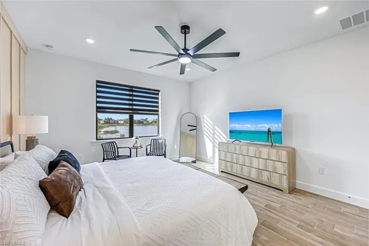 Bedroom featuring wood finish floors, a ceiling fan, and recessed lighting