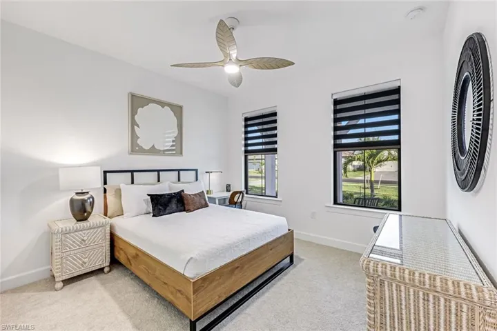 Bedroom with light carpet and a ceiling fan