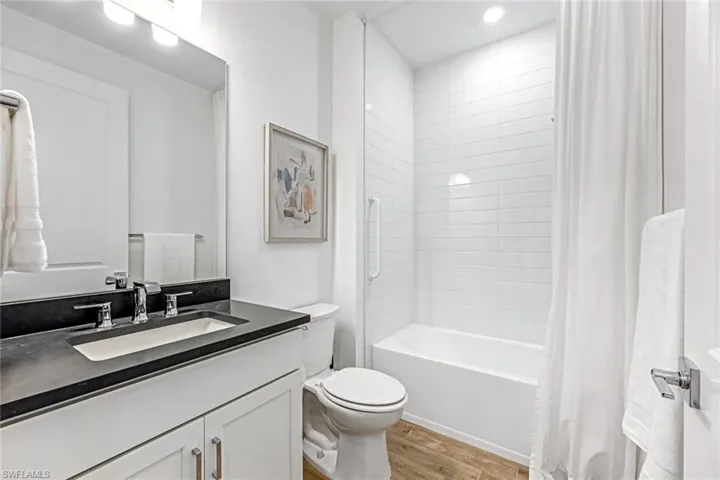 Bathroom with vanity, light wood-type flooring, and shower / tub combo