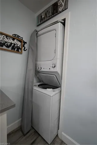 Stacked laundry appliances featuring a top-loading washer and front-loading dryer, integrated into a dedicated alcove