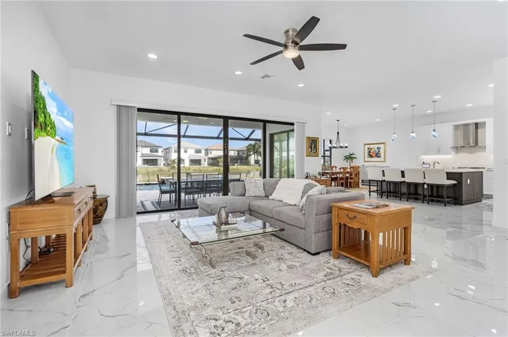 Open living area with a ceiling fan, light marble finish flooring, and recessed lighting