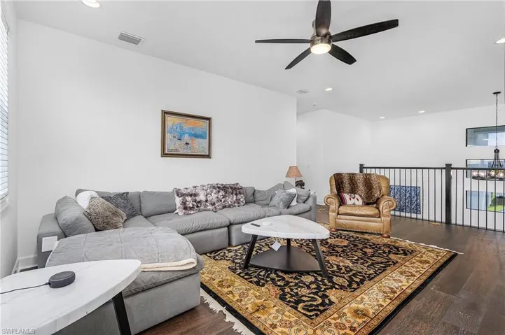 Loft featuring ceiling fan, recessed lighting, dark wood finished floors, and lake views
