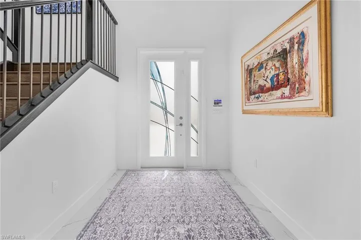 Custom Door with  tile flooring and upgraded railing with wood floor stairway