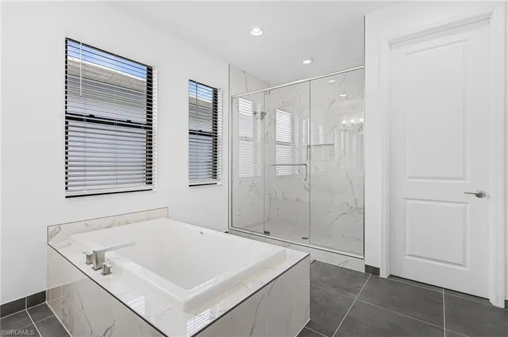 Primary Bath with dual sinks, extra storage, soaking tub, walk in shower, water closet and linen closet