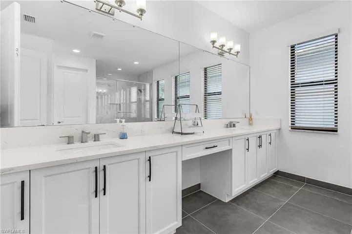 Primary Bath with dual sinks, extra storage, soaking tub, walk in shower, water closet and linen closet