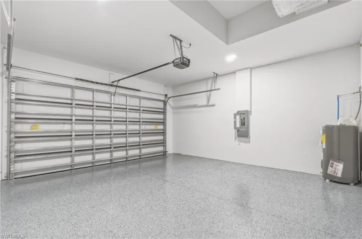 Garage featuring electric panel and a garage door opener