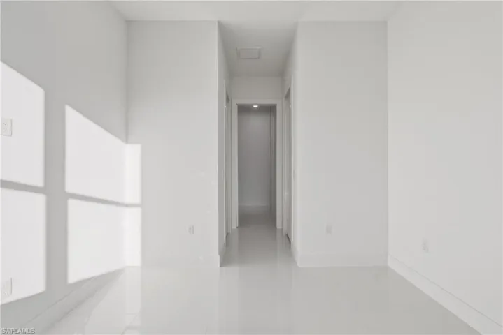 Empty room featuring light tile patterned flooring and baseboards