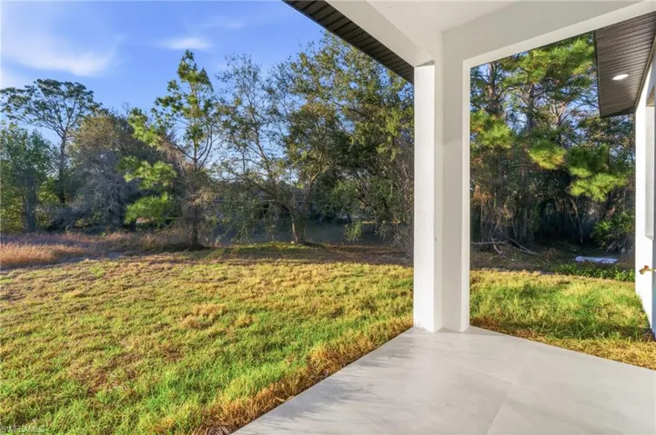 View of grassy yard with a patio area