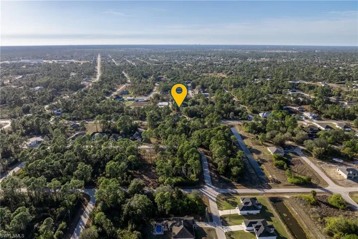 Aerial view of property and surrounding area with nearby suburban area