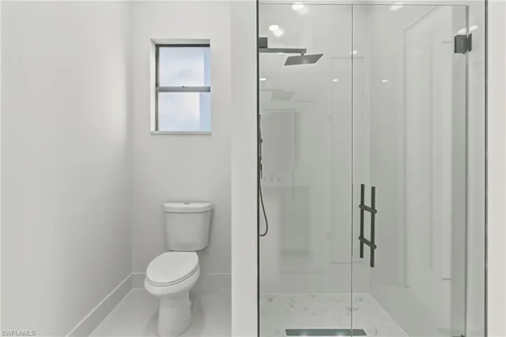 Bathroom with a stall shower and tile patterned floors