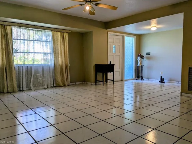 Entryway featuring light tile patterned floors and a ceiling fan