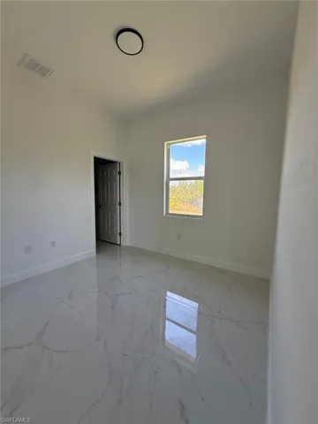 Spare room with light marble finish floors and baseboards