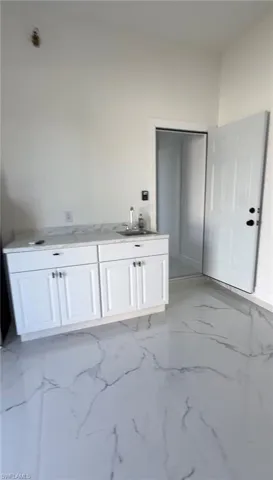 Bathroom with light marble finish flooring and vanity