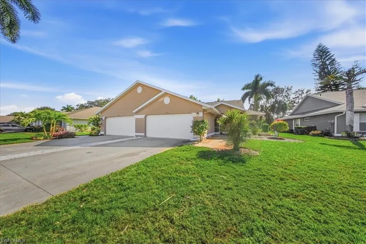 Single story home with a front yard, driveway, stucco siding, and an attached garage