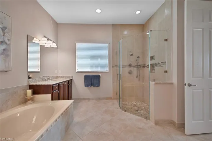 MASTER BATH FEATURES: SOAKING TUB, FLOOR TO CEILING TILE, AND FRAMELESS SHOWER DOOR.