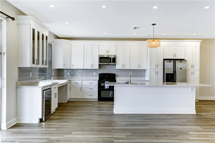 Large breakfast bar, quartz counters, and plenty of white cabinetry!