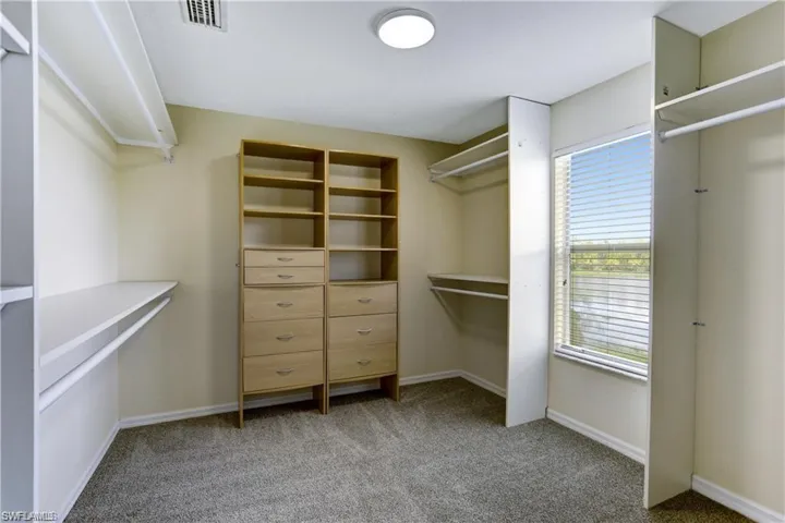Huge primary closet with built in cabinetry and window letting the light in!