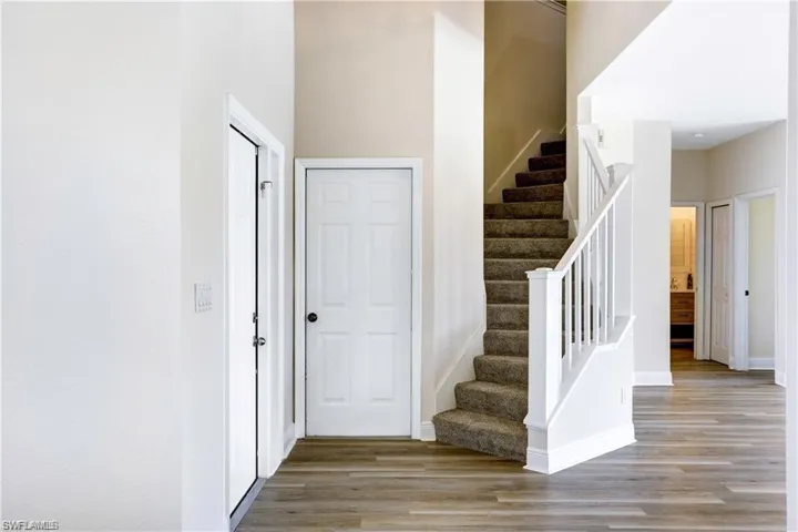 Entry door and other door leading out to the garage. Brand new carpet on stairs.