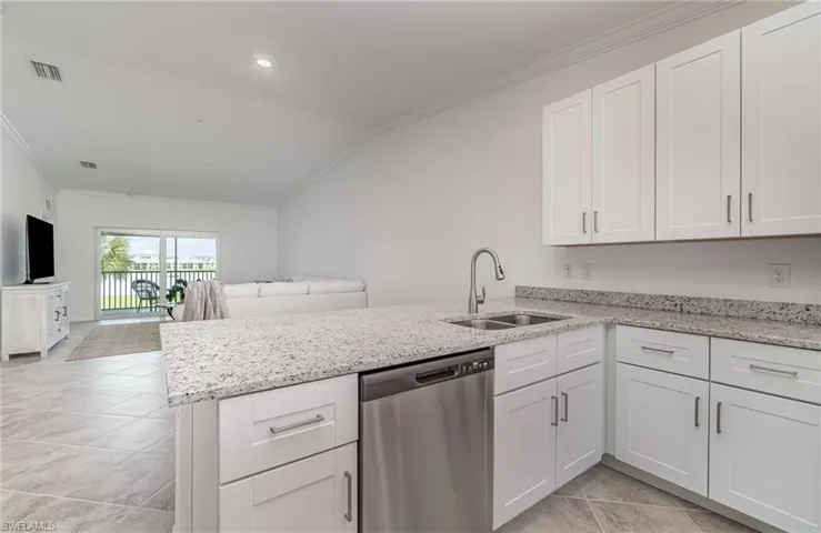 Kitchen with white cabinets, sink, and dishwasher