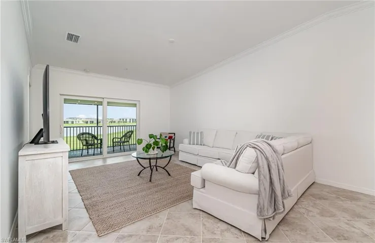 Living room with ornamental molding and light tile patterned floors