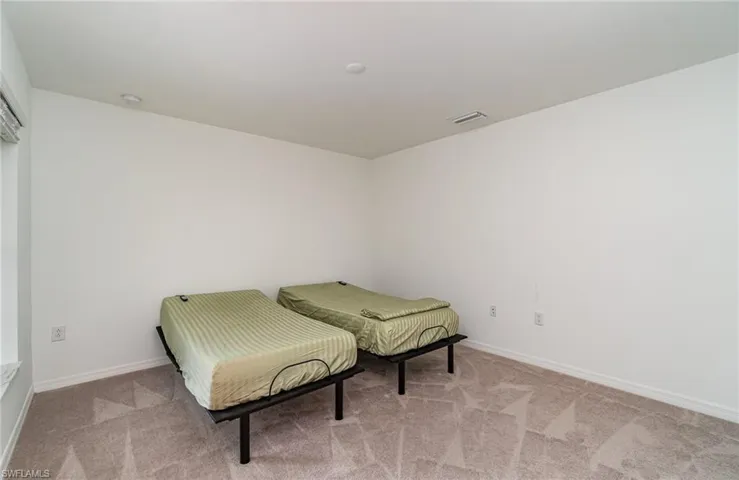 Bedroom featuring light colored carpet