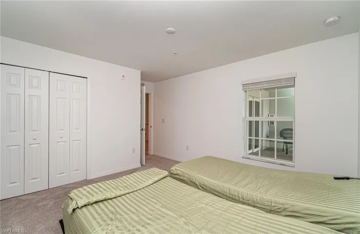 Carpeted bedroom with a closet