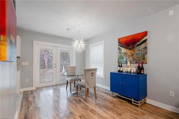 Dining room with an inviting chandelier, french doors, and light hardwood / wood-style floors