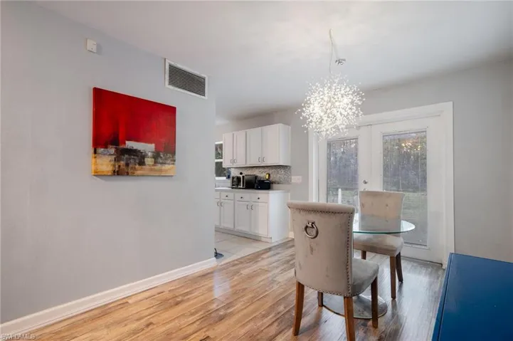 Dining space with a chandelier, french doors, and light hardwood / wood-style flooring