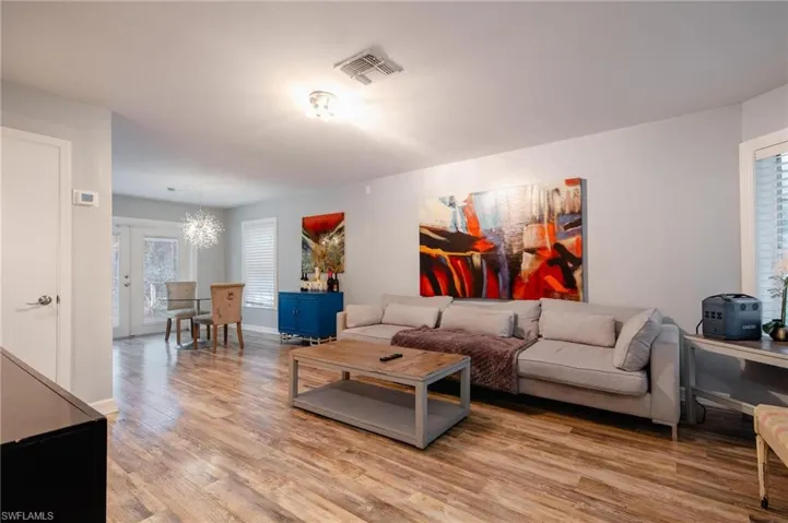 Living room featuring plenty of natural light, a notable chandelier, and light hardwood / wood-style flooring