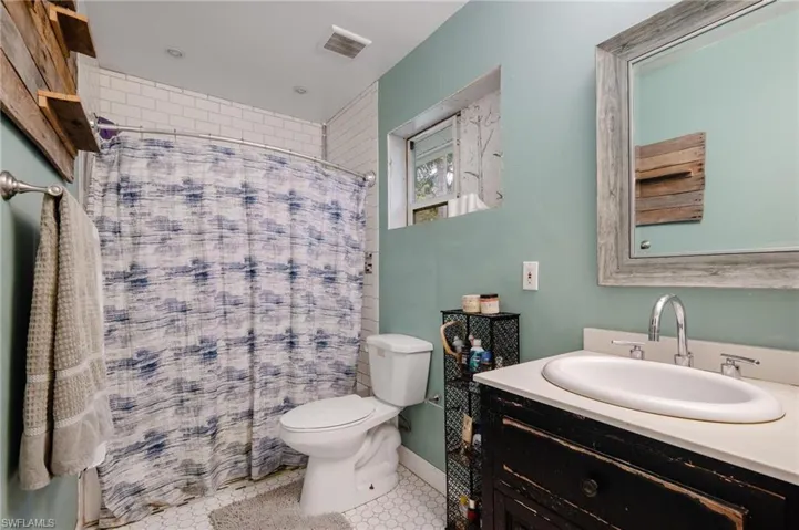 Bathroom with tile patterned flooring, vanity, toilet, and a shower with shower curtain
