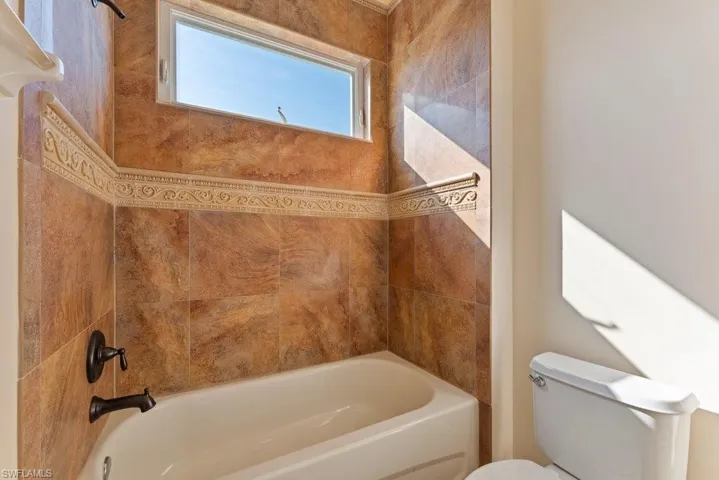 Full bathroom with toilet and bathing tub / shower combination