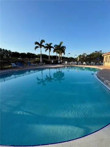 Community pool featuring a patio and fence