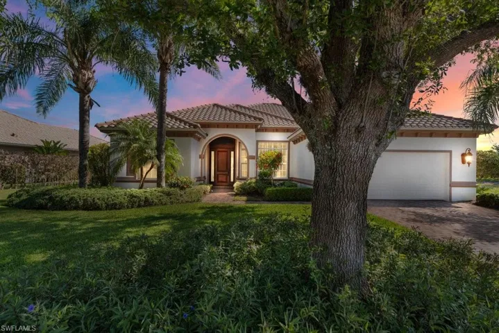 Mediterranean / spanish house featuring stucco siding, driveway, a front yard, a garage, and a tiled roof
