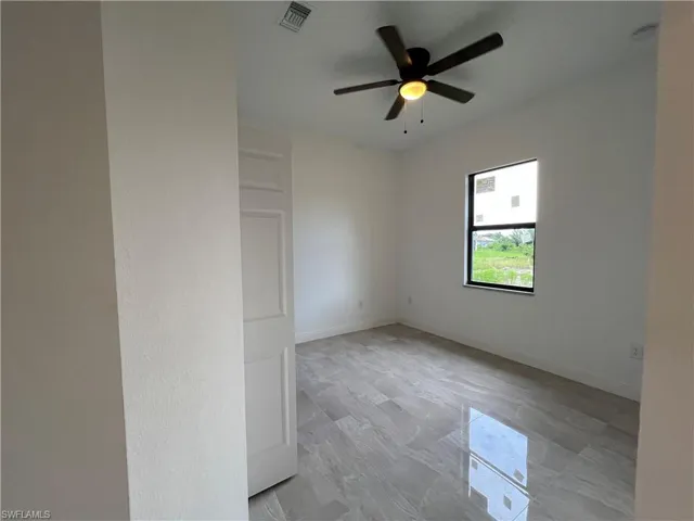 Spare room featuring ceiling fan and light tile patterned floors