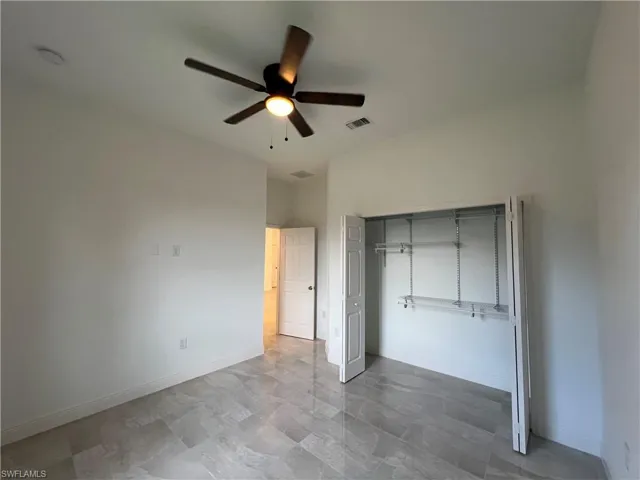 Unfurnished bedroom featuring ceiling fan, a closet, and light tile patterned floors