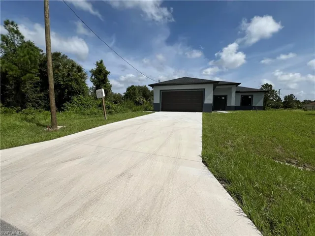 View of front of house featuring a front lawn and a garage