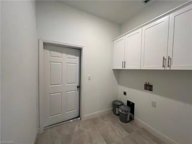 Laundry area featuring hookup for an electric dryer, washer hookup, cabinets, and light tile patterned flooring