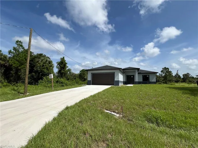 View of front of house featuring a garage and a front lawn