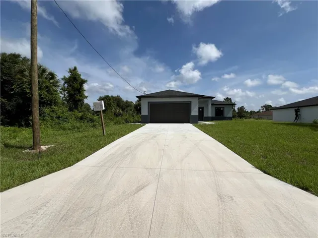 View of front of house featuring a garage and a front yard