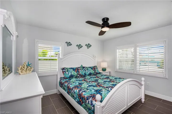 Bedroom with wood tiled floors and ceiling fan - Virtually Edited Image