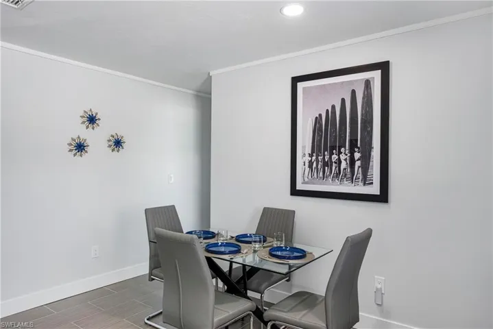 Dining space featuring crown molding, wood finish floors, and recessed lighting - Virtually Edited Image