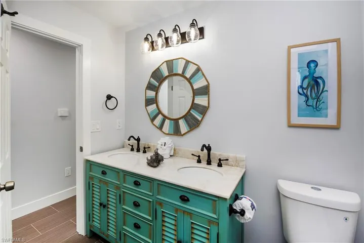 Bathroom with double vanity and wood finish floors - Virtually Edited Image