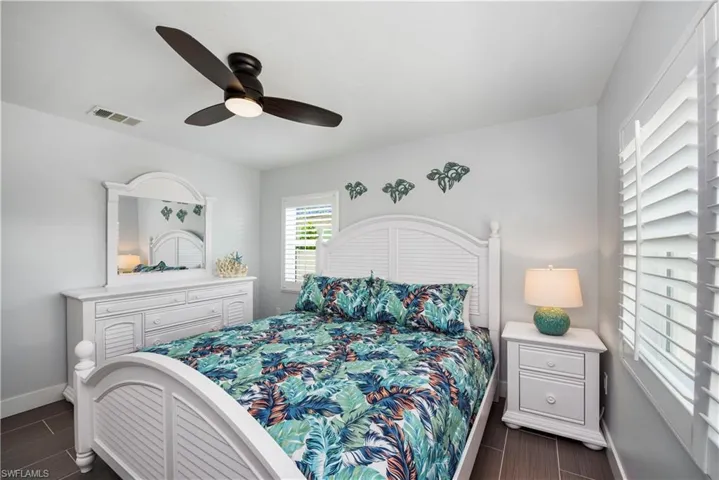 Bedroom featuring wood finish floors and a ceiling fan - Virtually Edited Image